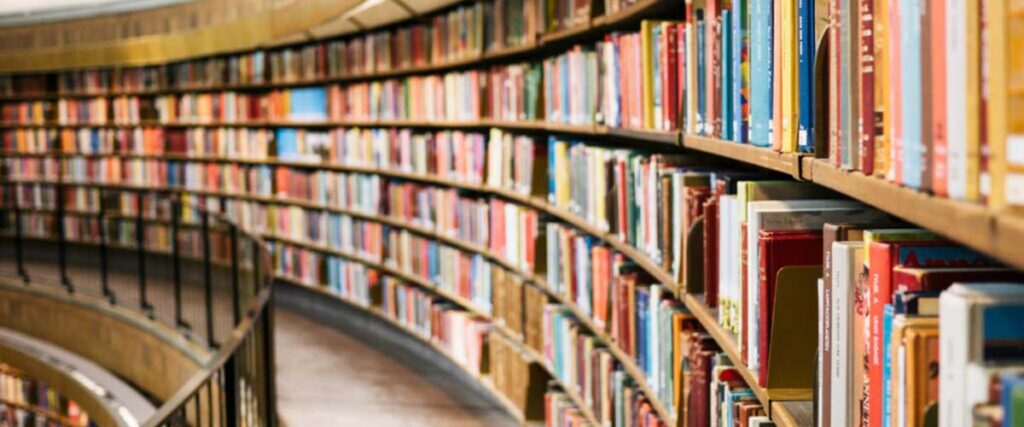 A library with a large, curved bookcase filled with books.