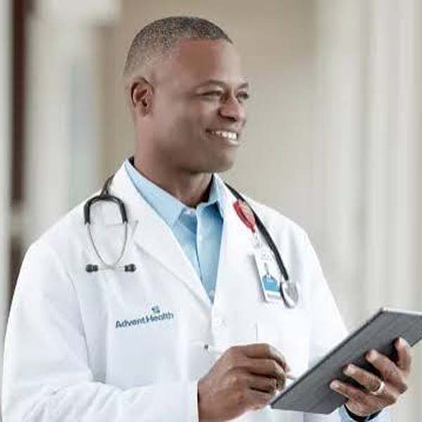 A male doctor in a lab coat holding a tablet.
